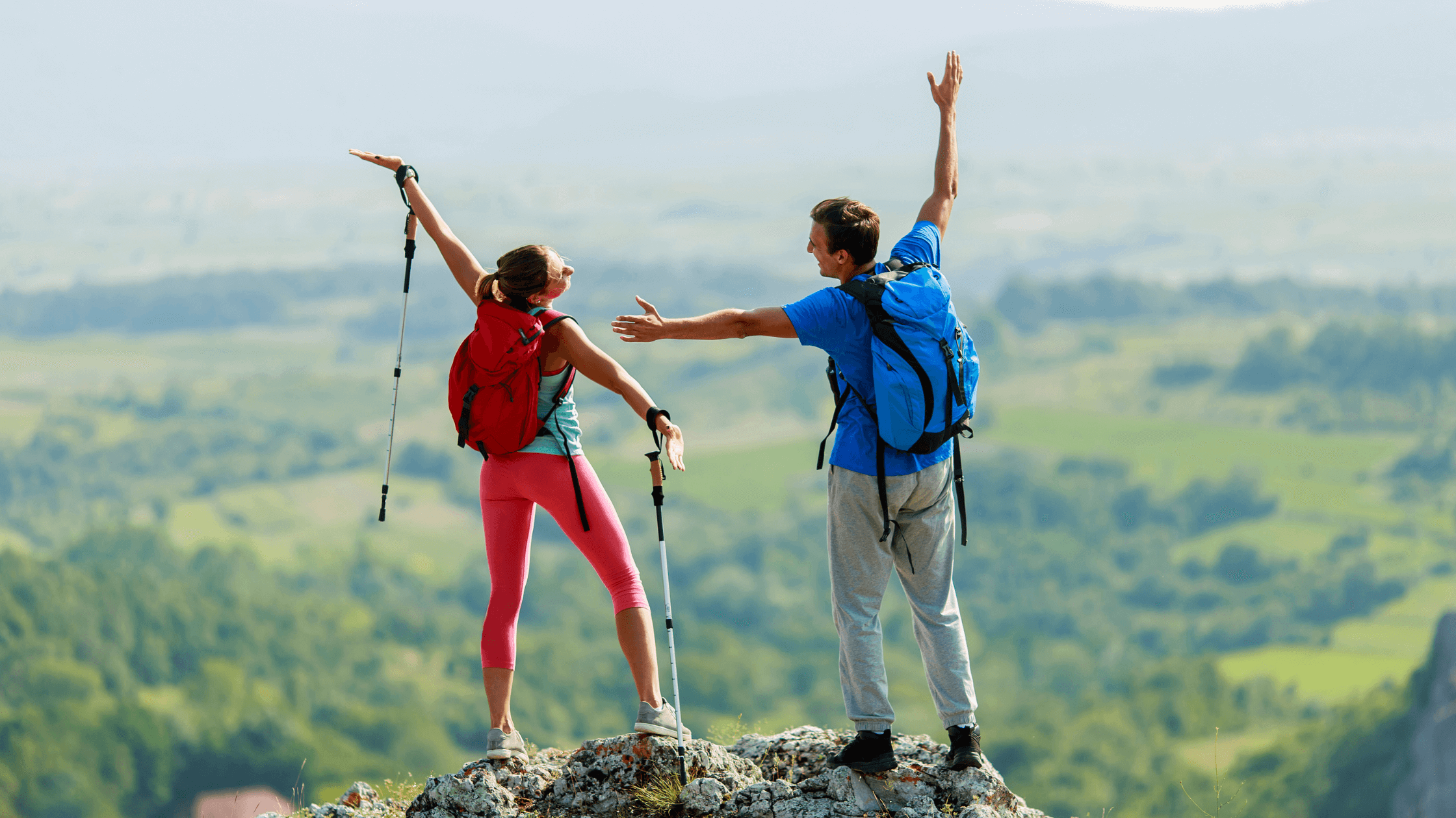 Two people celebrating on a mountaintop, symbolizing the active lifestyle achievable with effective chronic pain management and potentially through advanced treatments like regenerative medicine.