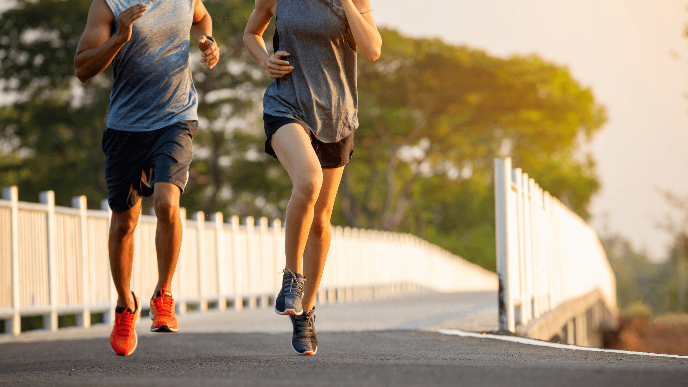 A man and woman running outdoors on a bridge at sunset, symbolizing an active, pain-free lifestyle achieved through effective pain management solutions like spinal cord stimulators.